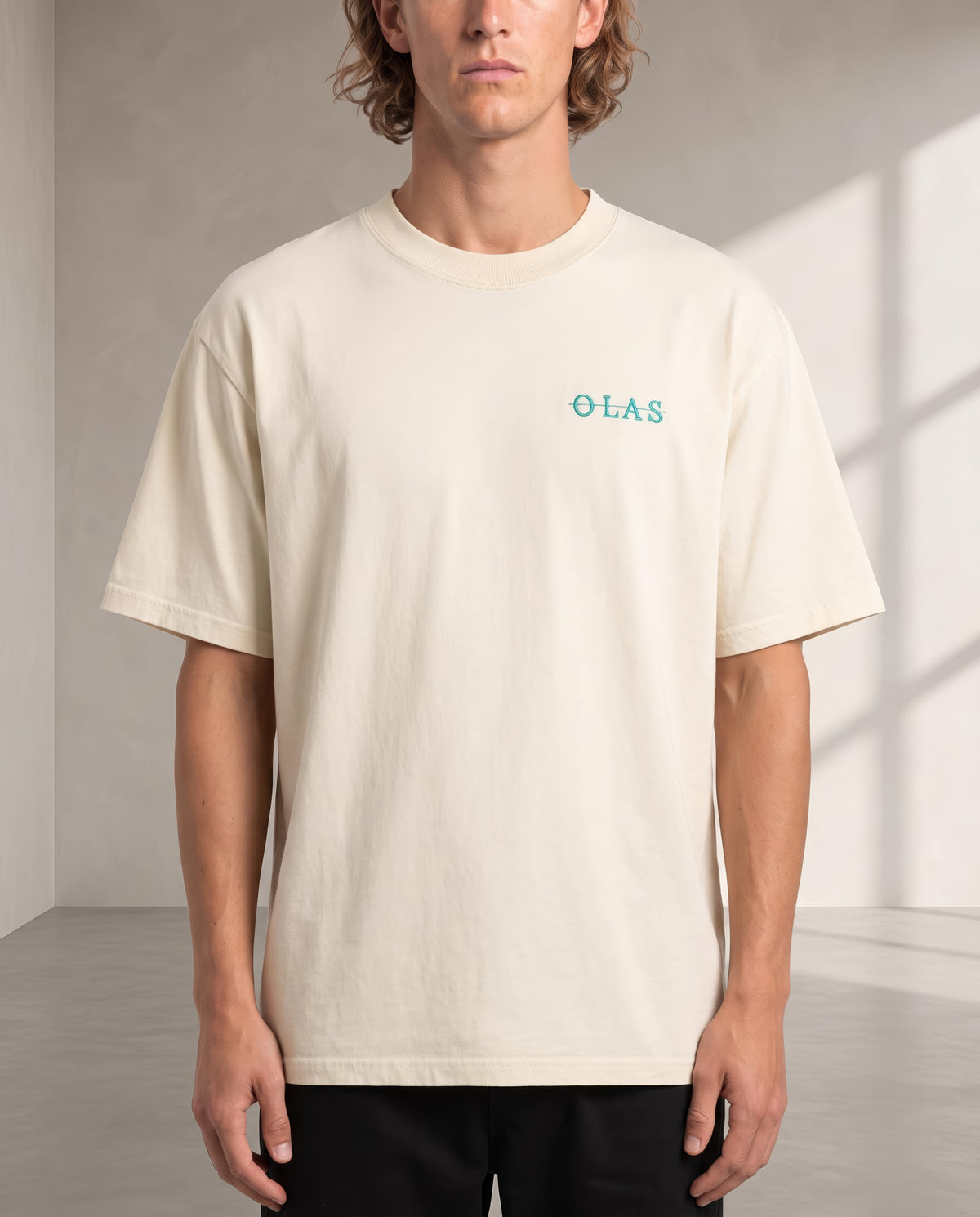 Front of the cream tee on the body, with the embroidered OLAS mark at the left chest