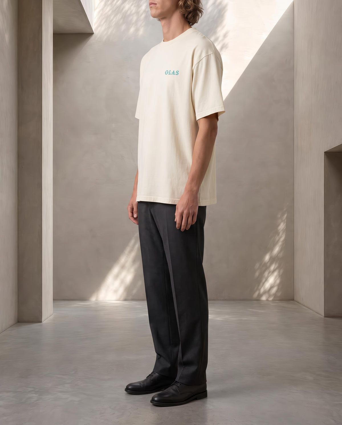 Side view of the cream tee on a model, showing how it falls from shoulder to hem