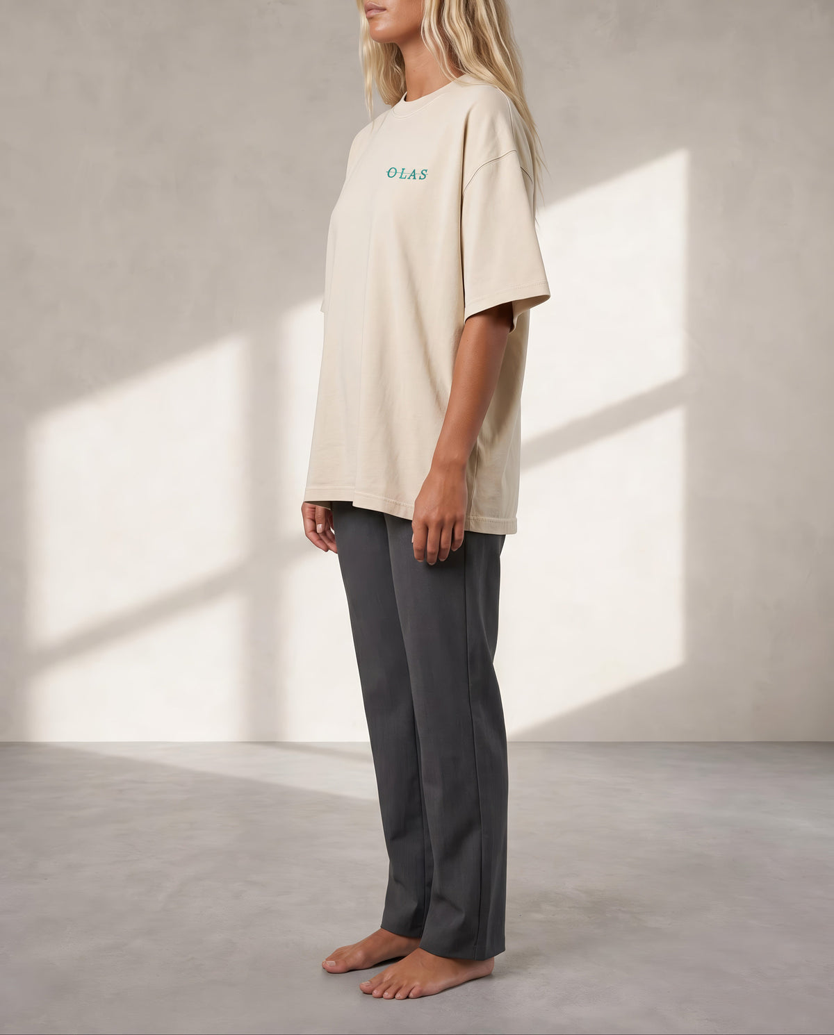Side view of the cream tee on a model, showing how it falls from shoulder to hem