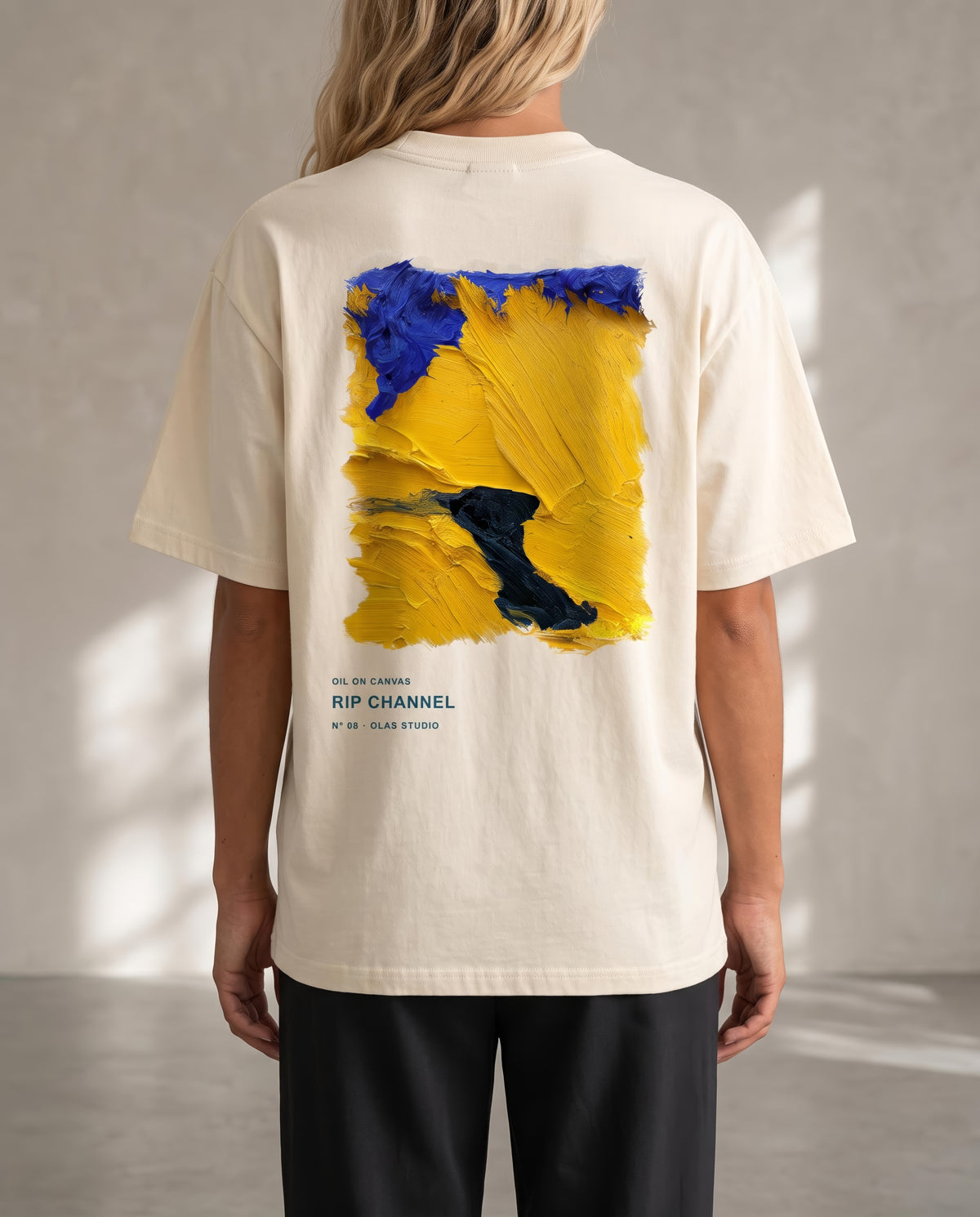A model seen from the back in the Rip Channel tee, the work printed large across the upper back