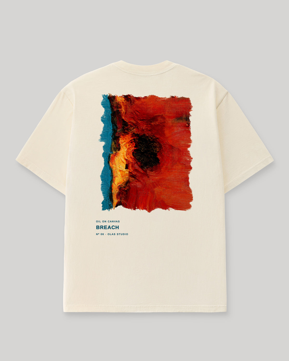 Back of a cream Olas Studio T-shirt with Breach: a teal strip beside a red field, split by black and gold along a vertical break.