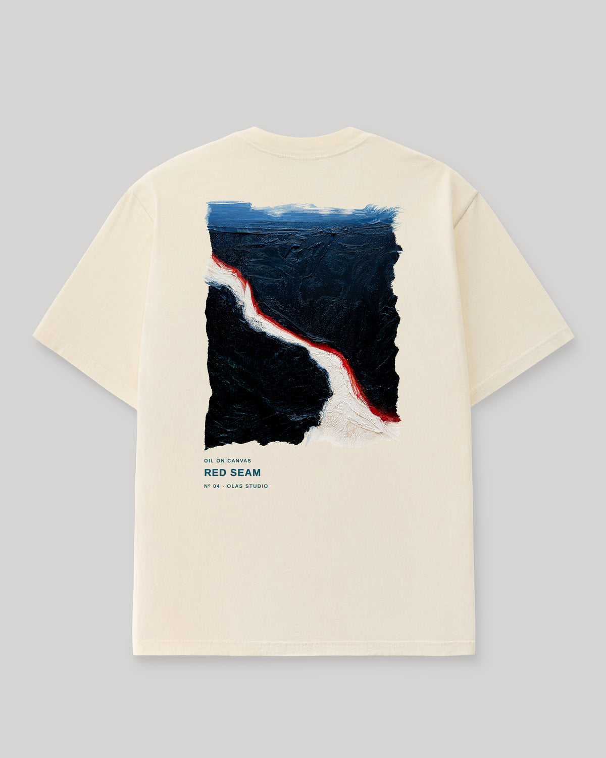 Back of a cream Olas Studio T-shirt with Red Seam: a jagged white diagonal through near-black fields, edged in red beneath a blue band.