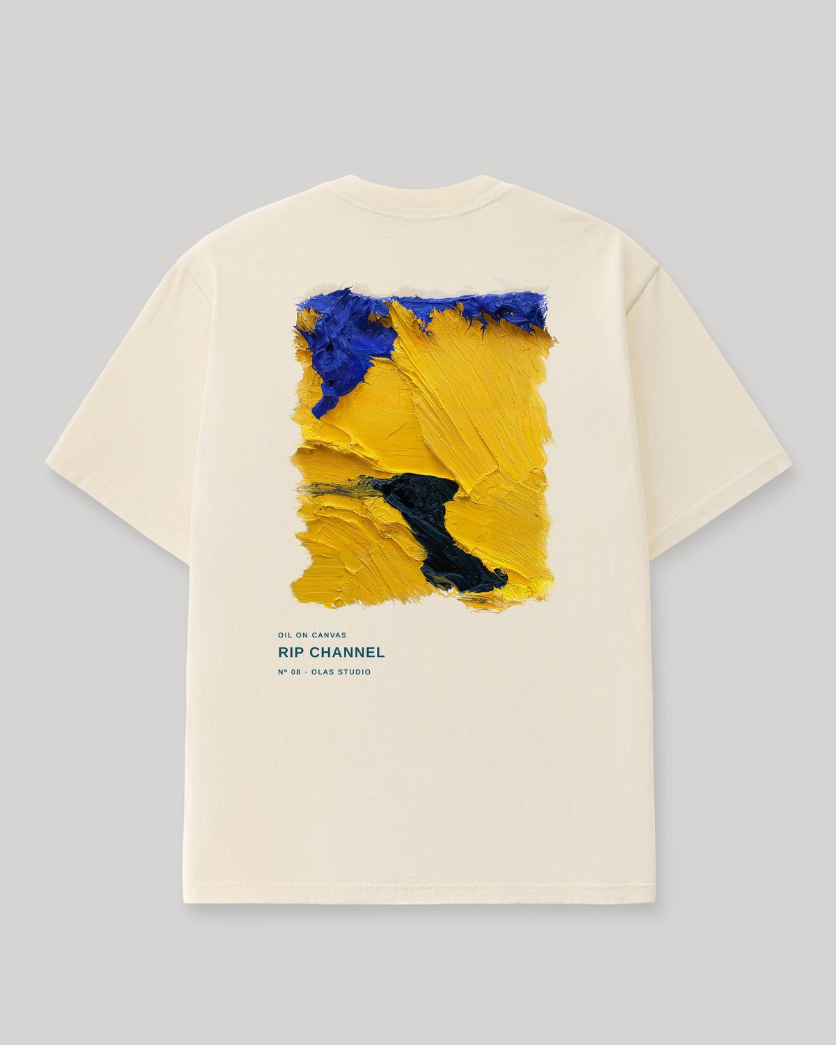 Back of a cream Olas Studio T-shirt with Rip Channel: broad yellow strokes cut by a dark navy channel, with violet-blue along the top edge.