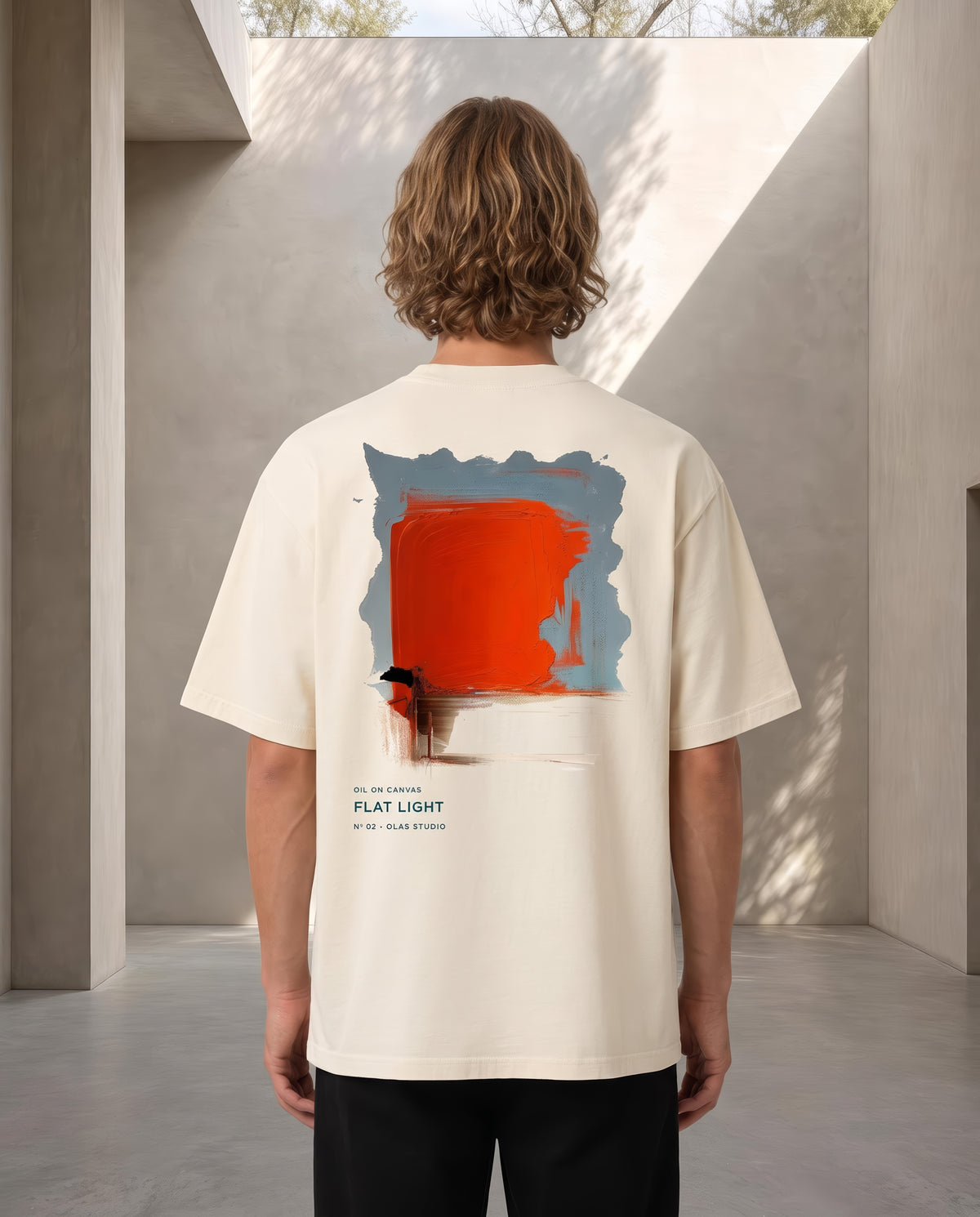 A model seen from the back in the Flat Light tee, the work printed large across the upper back
